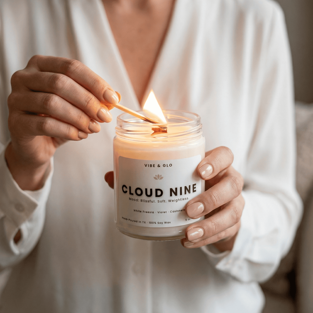 Woman lighting a clean-burning soy wax candle in a glass jar, demonstrating how to choose a high-quality scented candle for home fragrance.
