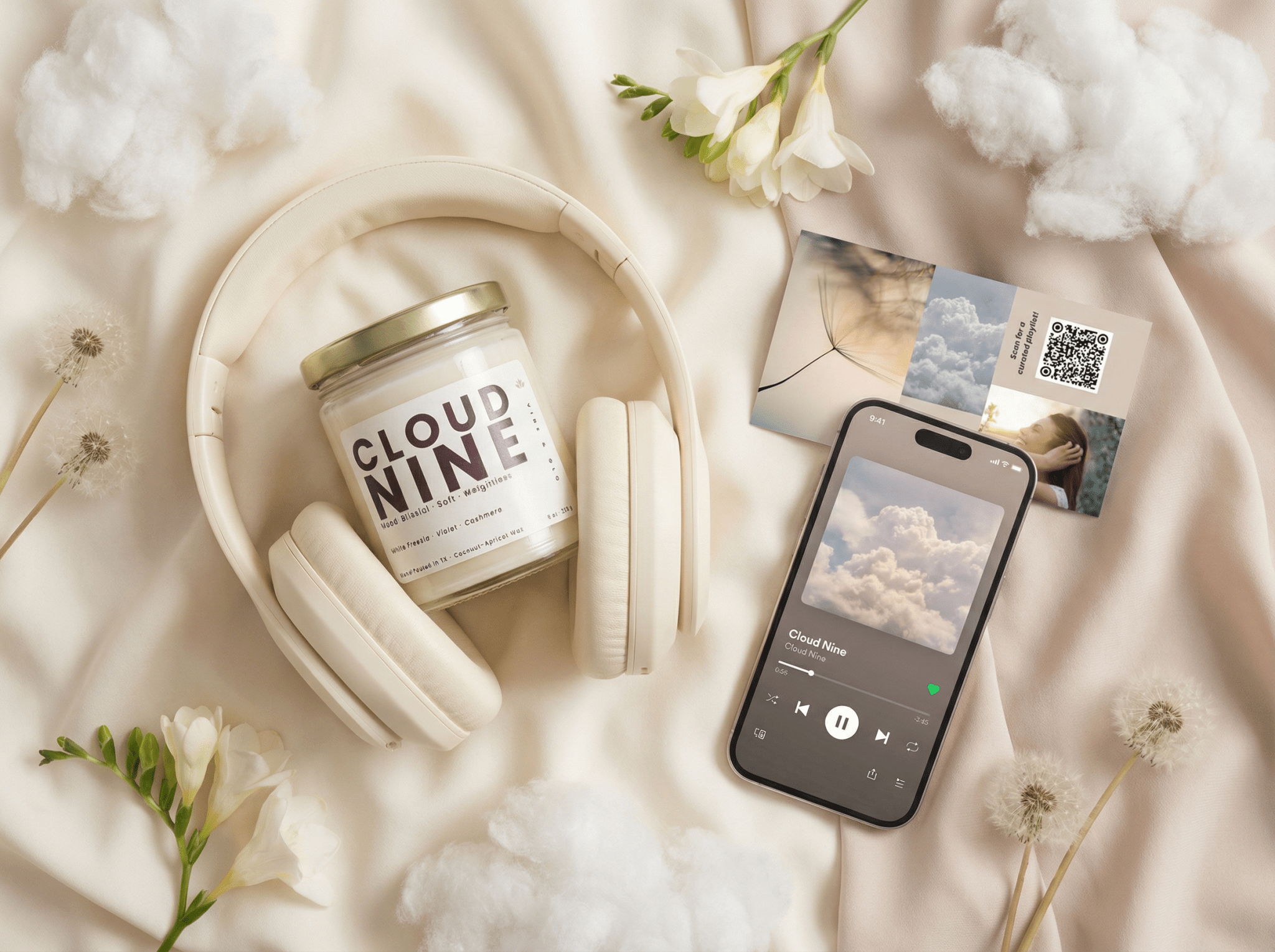 Flatlay of Cloud Nine candle with headphones, smartphone playing a playlist, and mood card, representing scent and sound pairing experience by Vibe & Glo Candle Studio