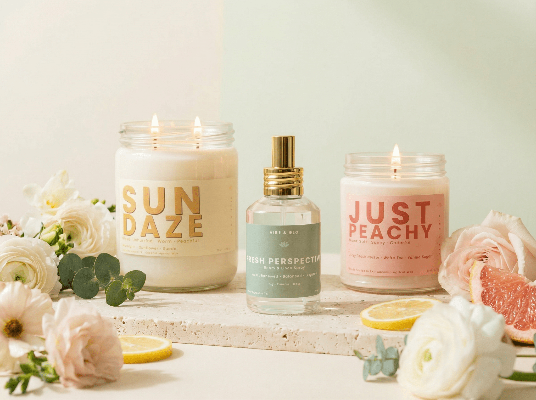 Vibe & Glo Spring 2026 home fragrance collection featuring Sun Daze and Just Peachy candles with Fresh Perspective room and linen spray styled with florals and citrus
