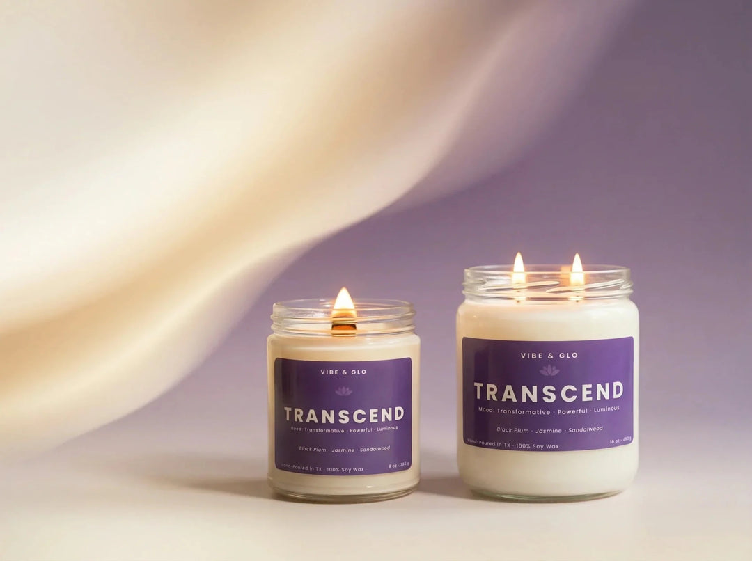 Vibe & Glo Transcend soy candles featuring a single wooden wick candle beside a double cotton wick candle, both lit in clear glass jars with soft neutral and lavender styling