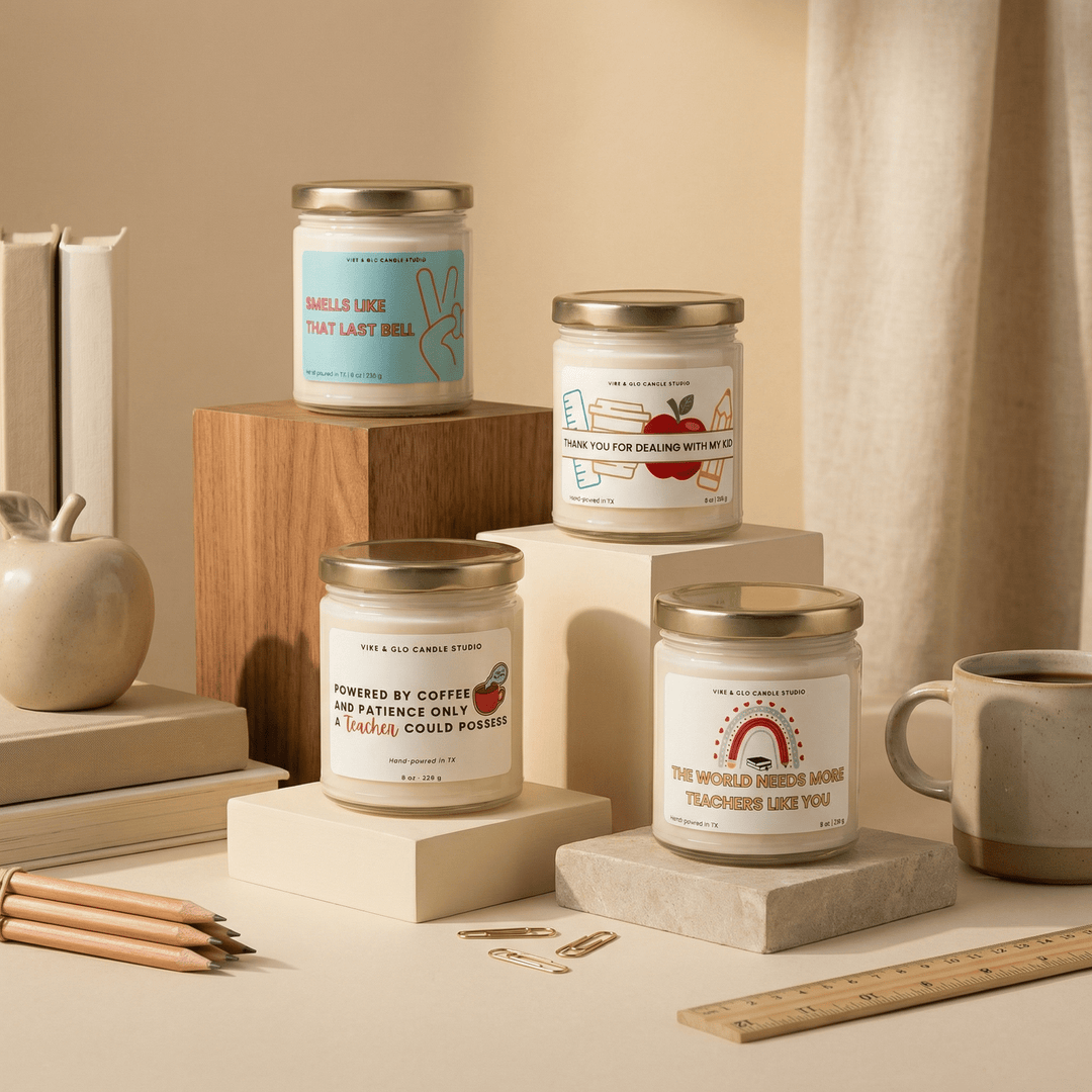 Teacher gift candle collection by Vibe & Glo featuring funny teacher appreciation candles in glass jars with wooden wicks, styled with books, coffee mug, and classroom accessories.
