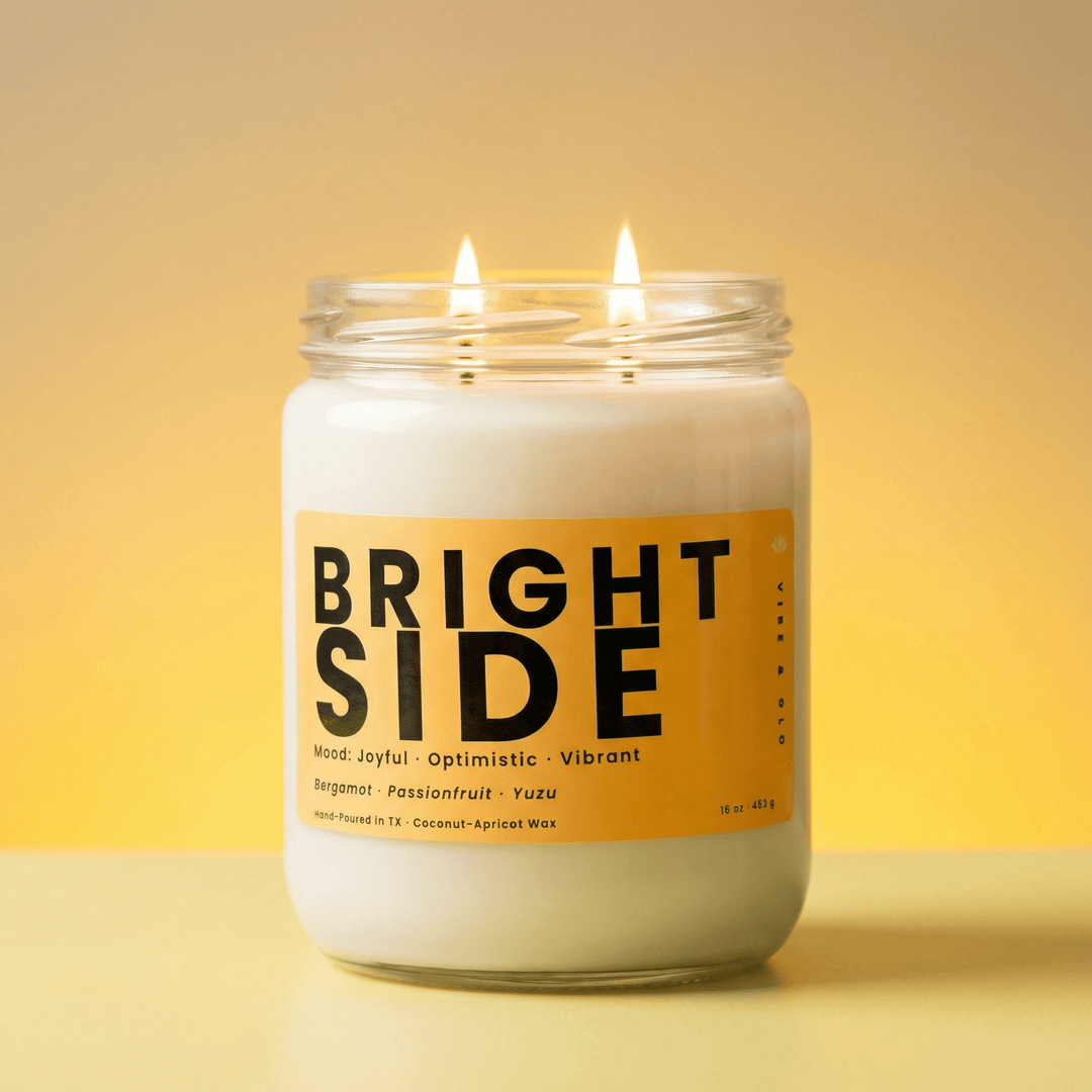 Bright Side 2-wick candle with two cotton wicks burning against a warm golden background, vibrant citrus candle