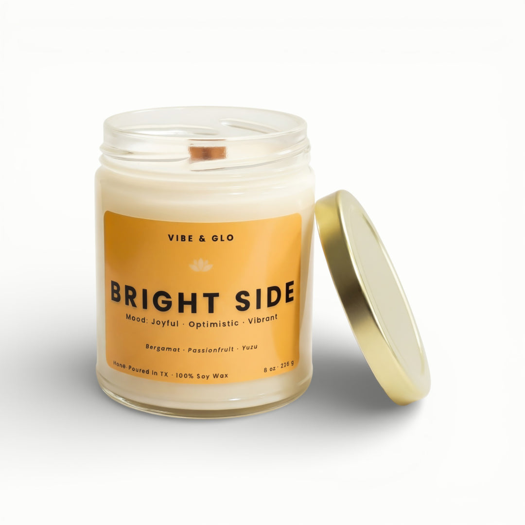 Vibe & Glo Bright Side soy candle in clear glass jar with wooden wick and gold lid, bergamot passionfruit and yuzu scent