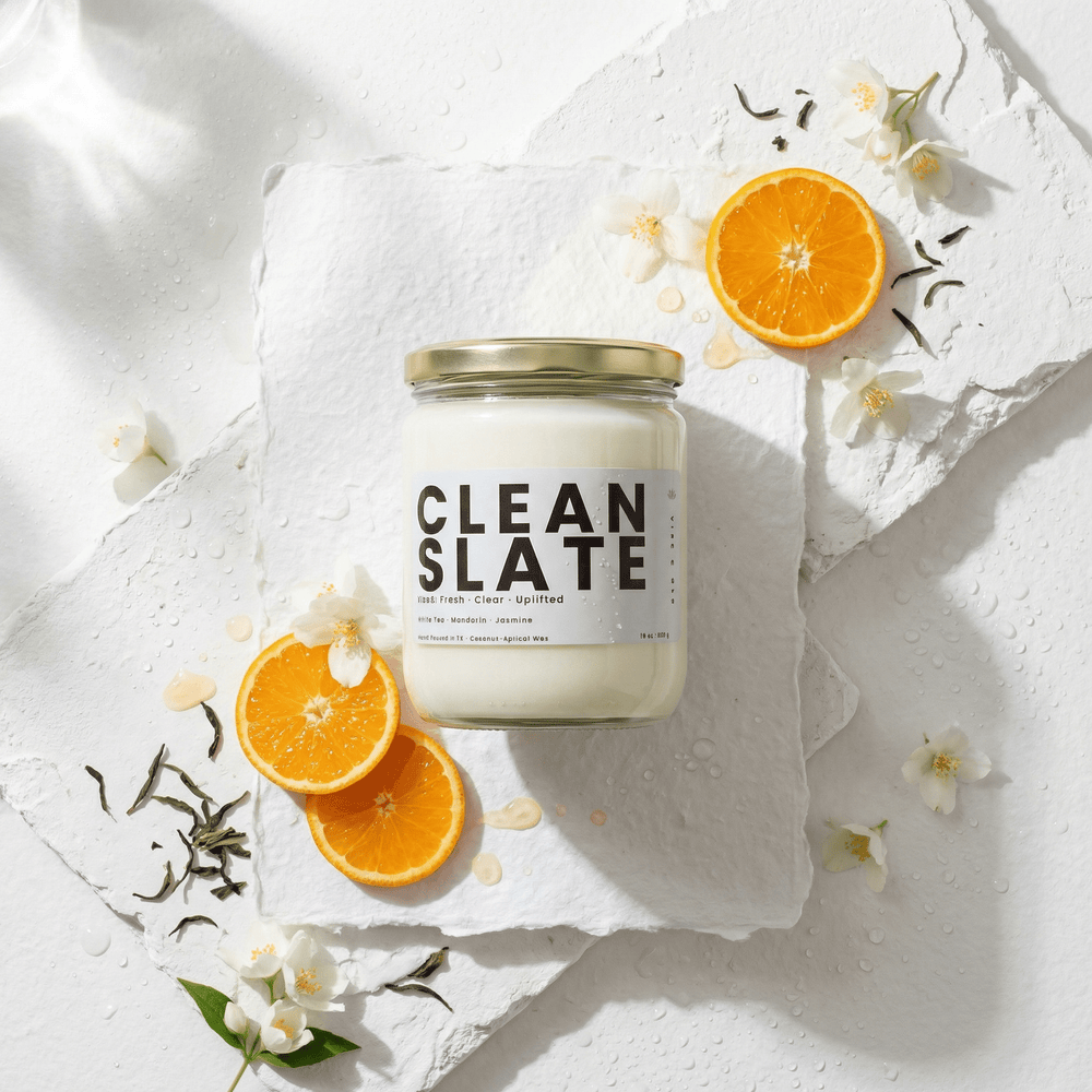 Clean Slate candle styled with orange slices, white florals, and tea leaves, fresh clean candle with citrus and white tea scent