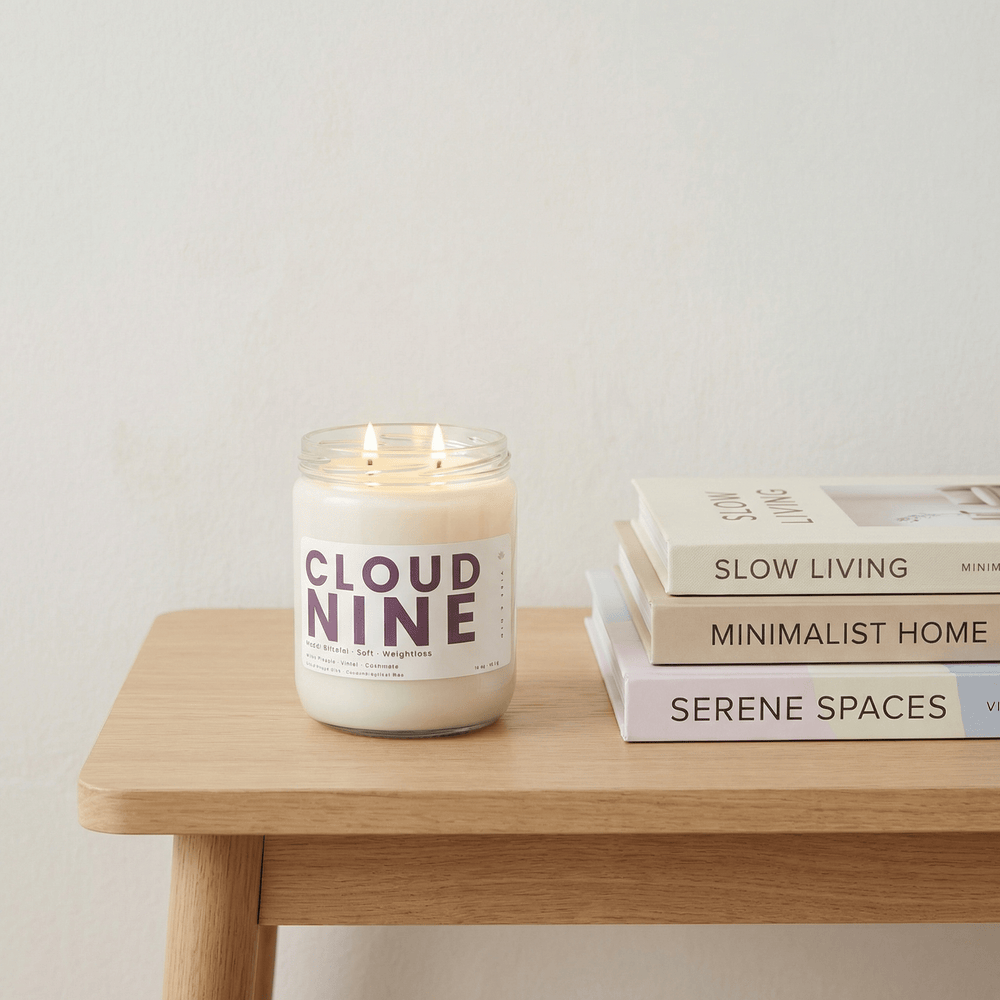 Cloud Nine candle on wooden table beside neutral home decor books, soft, clean candle for calming minimalist spaces