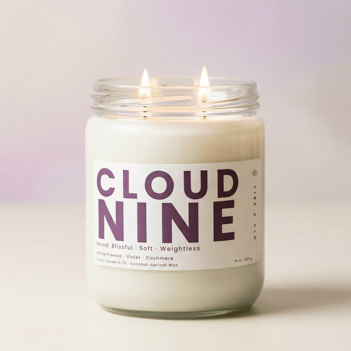 Cloud Nine 2-wick candle glowing on soft neutral background, clean fresh candle with light floral scent