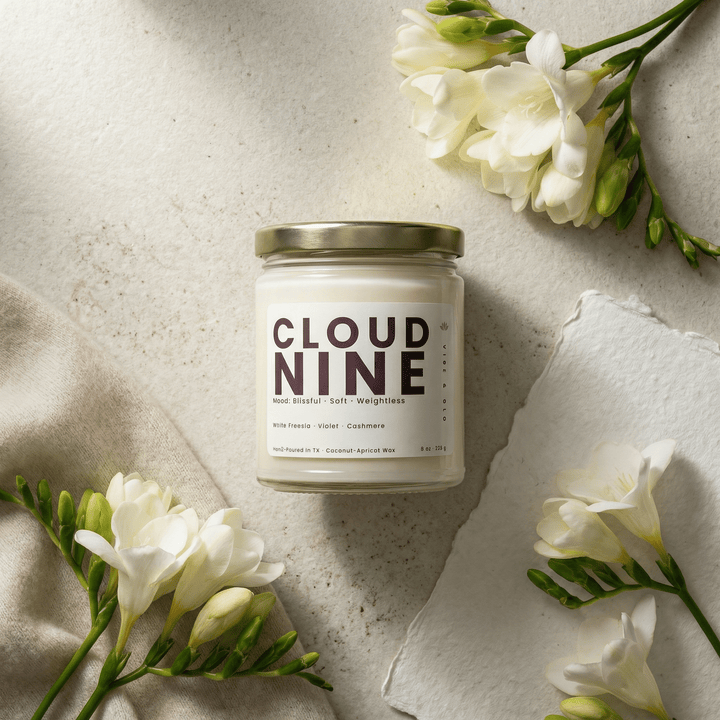 Cloud Nine candle styled with white freesia flowers on a soft neutral background representing a clean, soft floral home fragrance