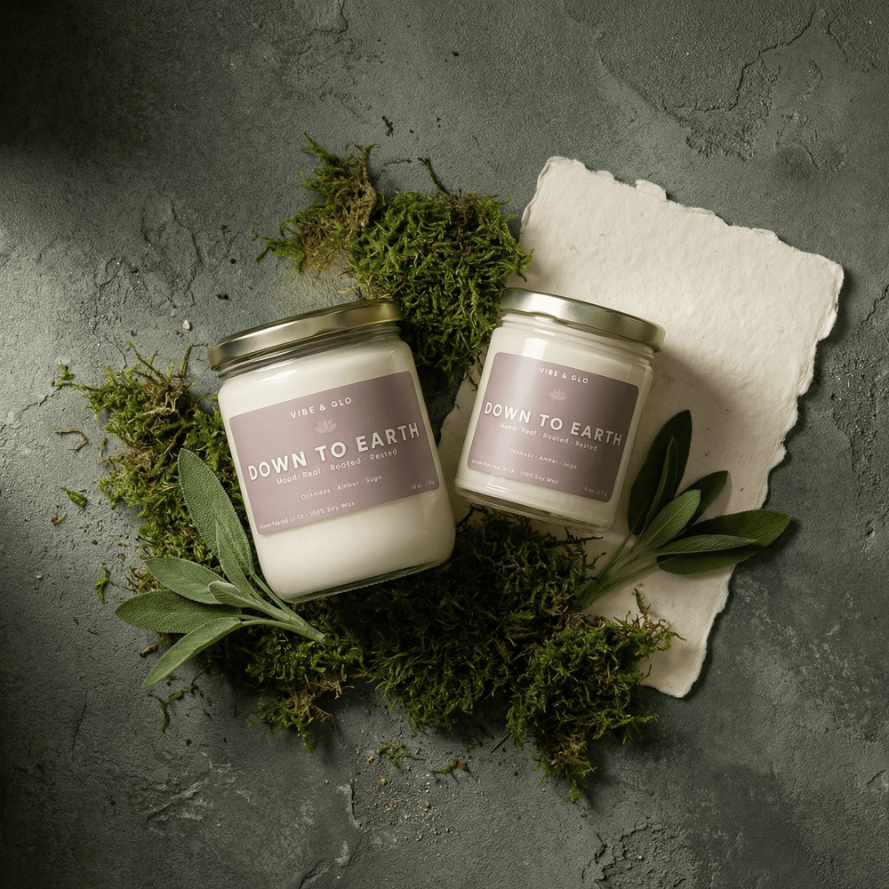 Down to Earth wooden wick soy candle in 16 oz and 8 oz jars styled with moss and sage, featuring oakmoss, amber, and sage notes.