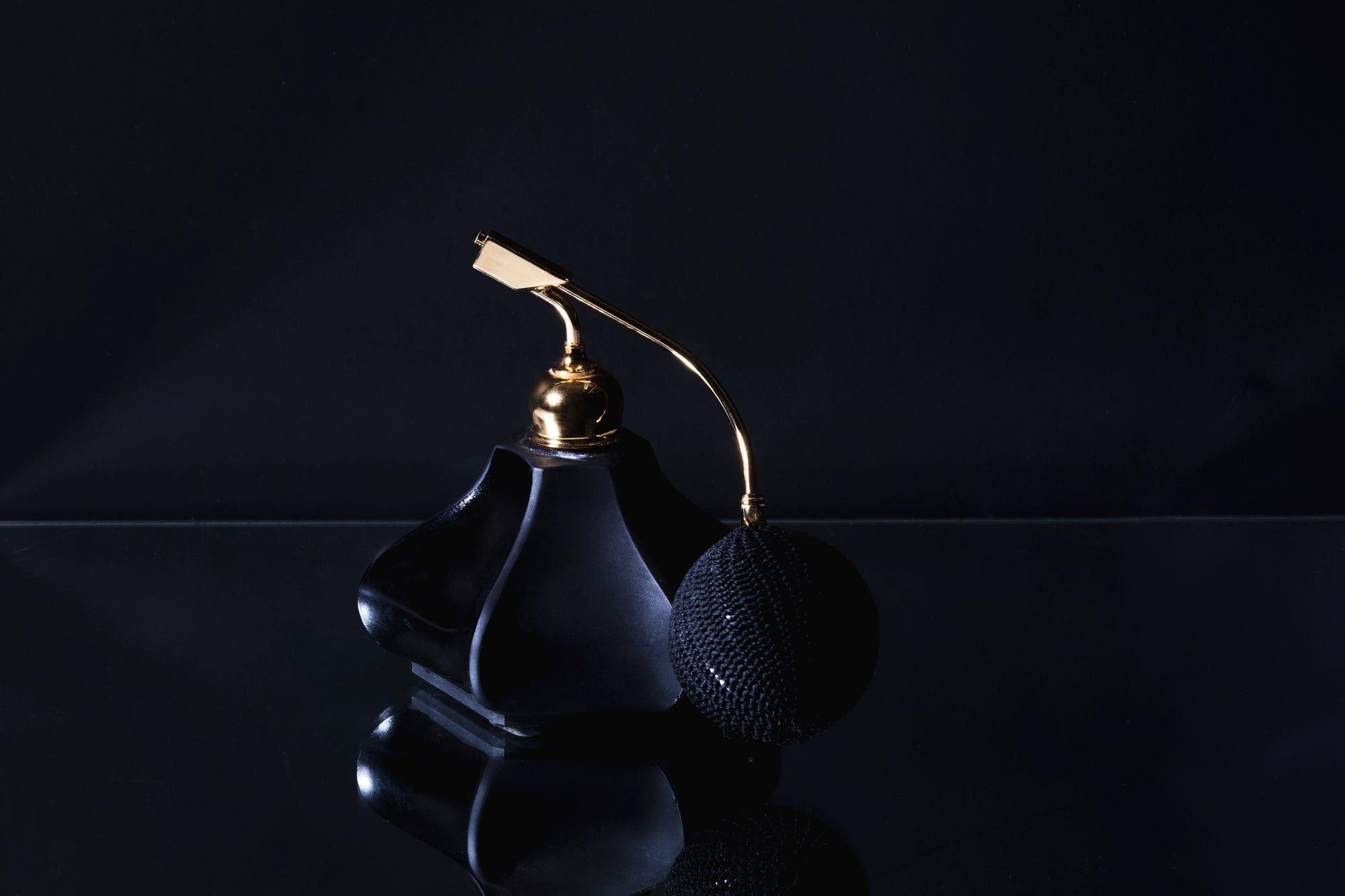 Black glass perfume bottle symbolizing the cologne-inspired fragrance of the Magnetic Reserve masculine wooden wick soy candle