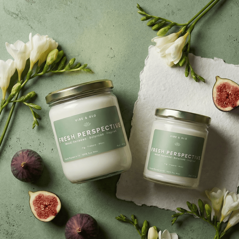 Fresh Perspective wooden wick soy candle in 16 oz and 8 oz jars styled with figs and white florals, featuring fig, freesia, and moss notes.