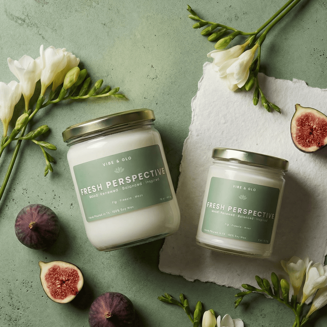 Fresh Perspective wooden wick soy candle in 16 oz and 8 oz jars styled with figs and white florals, featuring fig, freesia, and moss notes.