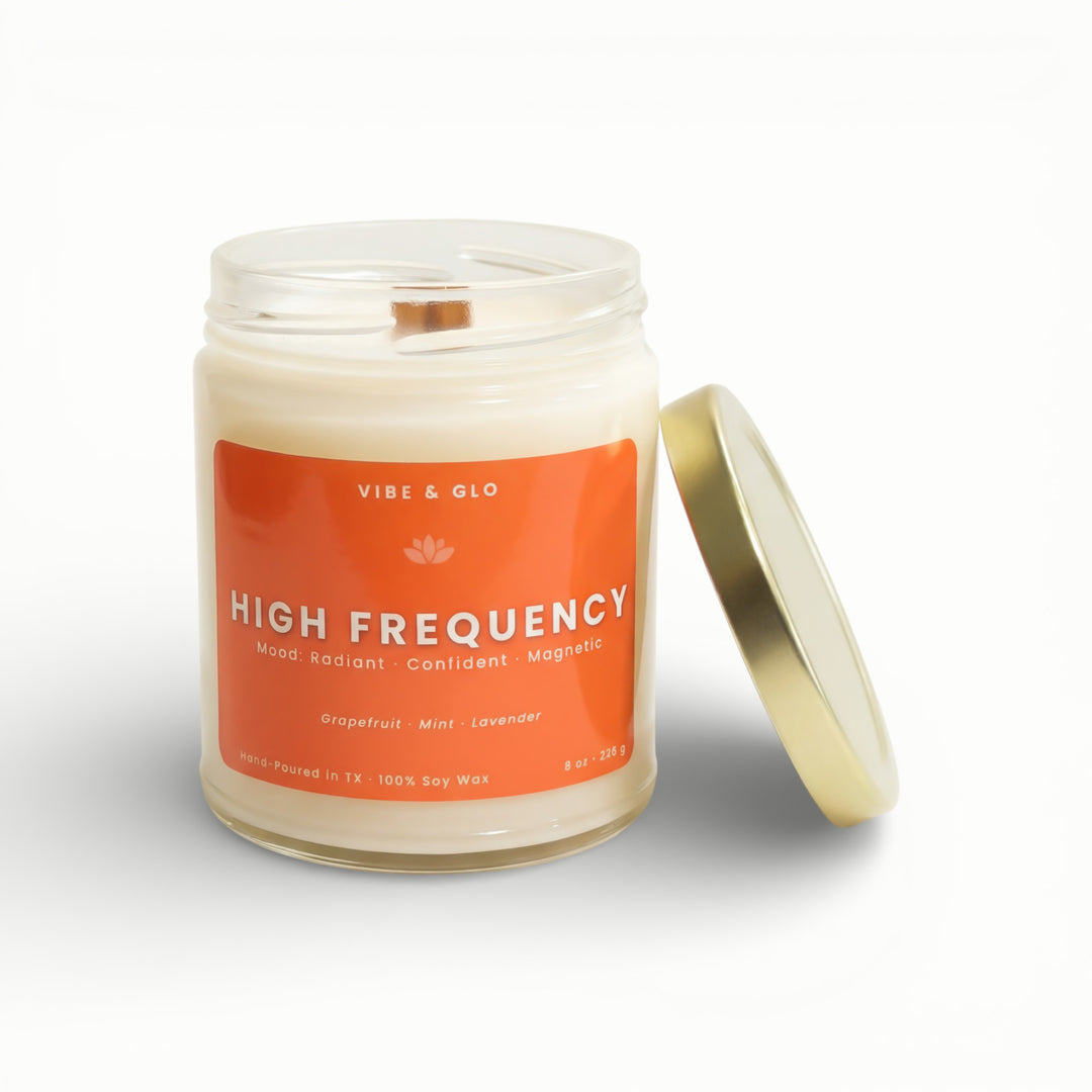 Vibe & Glo High Frequency soy candle in clear glass jar with wooden wick and gold lid, grapefruit mint and lavender scent