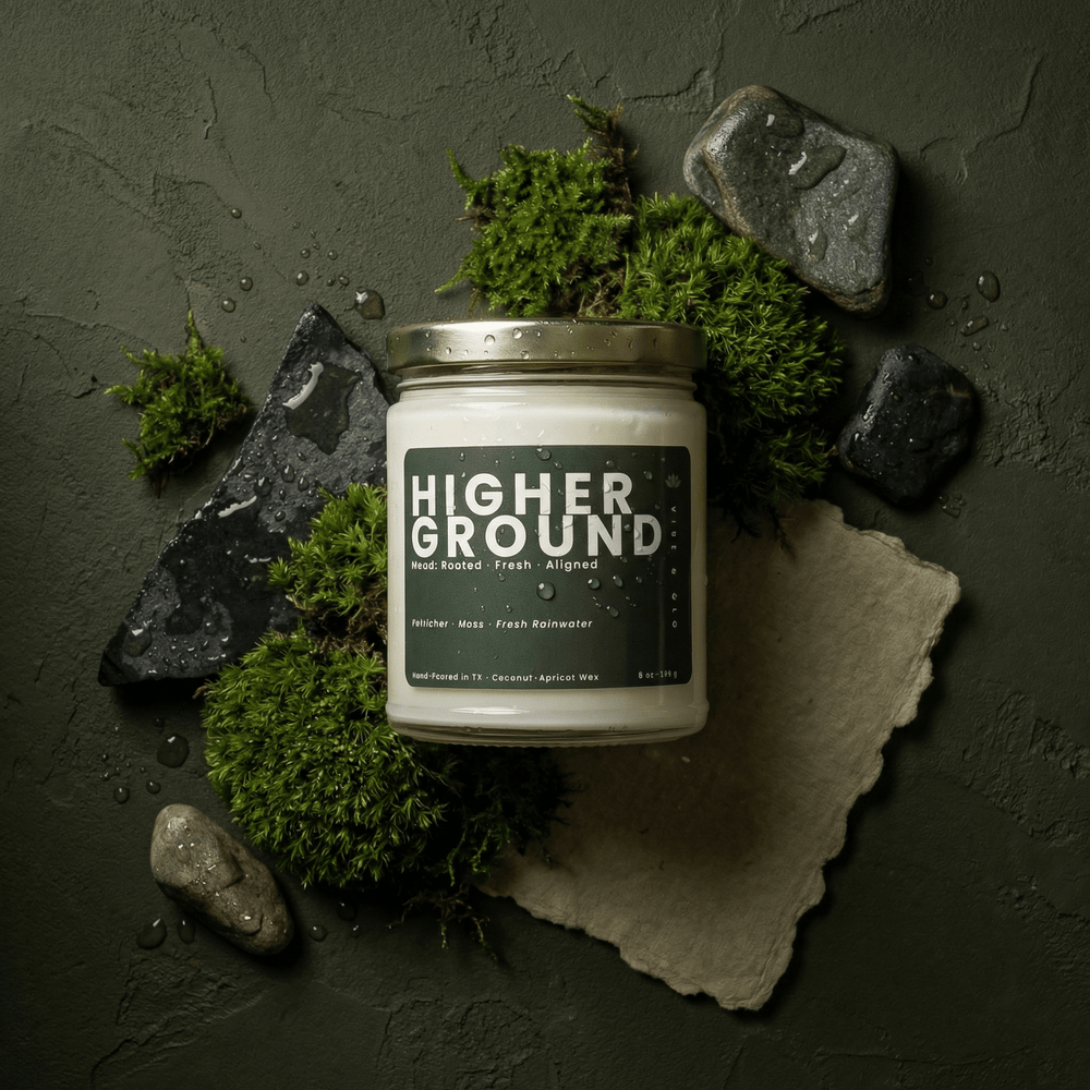 Higher Ground candle styled with moss, stones, and water droplets, earthy petrichor and fresh rain scent in coconut apricot wax