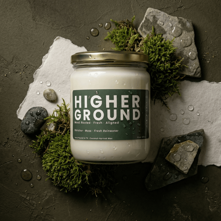 Higher Ground candle styled with moss, stones, and water droplets, earthy fresh candle inspired by rain and nature