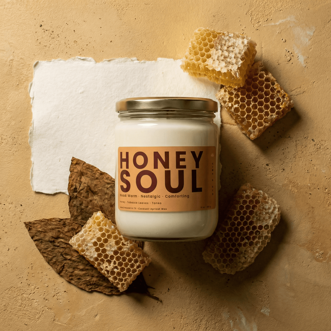 Honey Soul 2-wick candle flat lay with honeycomb and dried tobacco leaves, highlighting warm sweet and smoky fragrance notes