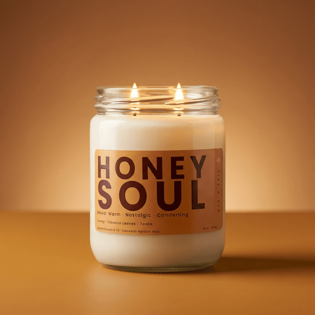 Honey Soul 2-wick honey & tobacco candle with two cotton wicks burning against a warm golden background, cozy modern product image