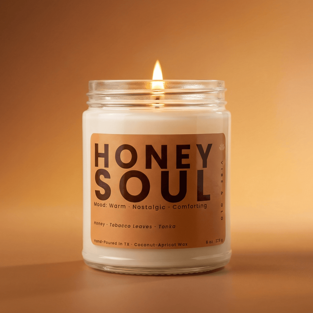 Honey Soul coconut apricot wax candle burning with a soft amber glow featuring warm notes of honey tobacco leaves and tonka