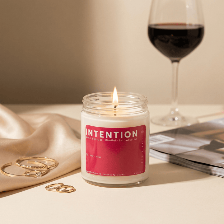 Intention candle styled with wine glass and gold jewelry, sensual fig pear musk scent creating a soft elevated self care mood