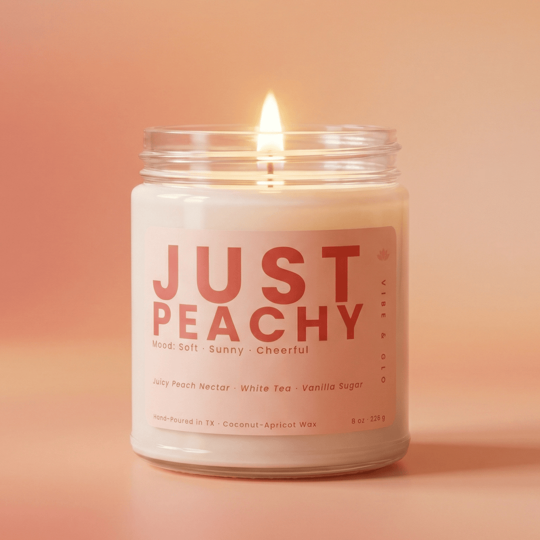 Just Peachy jar candle burning in soft peach-toned studio setting, bright fruity scent with peach nectar white tea and vanilla sugar