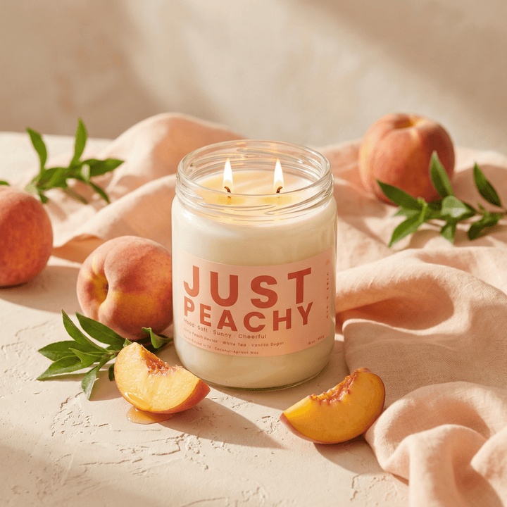 Just Peachy candle with fresh peaches and soft linen fabric in sunlight, bright fruity candle for a soft summer home vibe