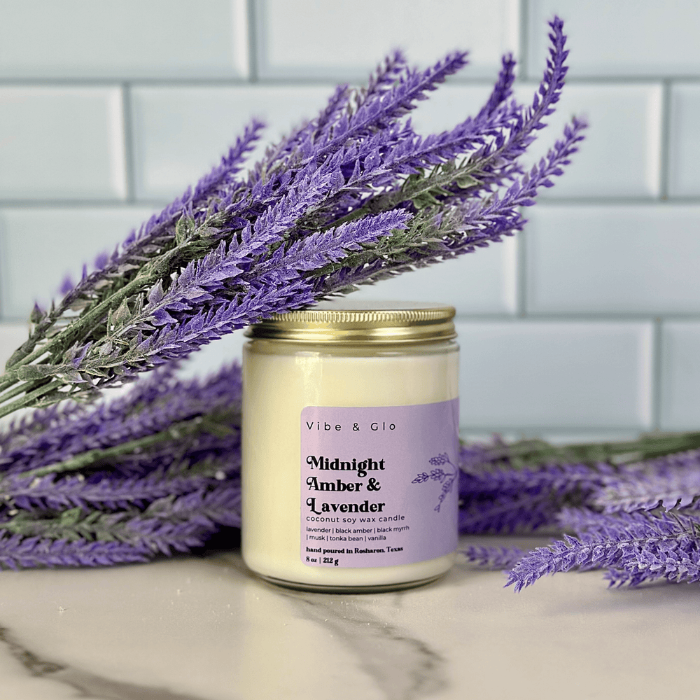 
                  
                    Midnight Amber & Lavender coconut soy wax candle displayed with sprigs of lavender, showcasing its eco-friendly and relaxing design.
                  
                