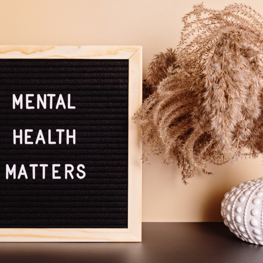 Black letter board with white text reading “Mental Health Matters,” styled with dried pampas grass and a textured white vase on a neutral background.