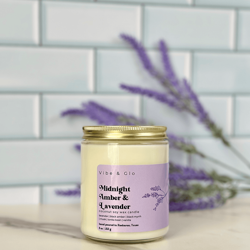 
                  
                    Midnight Amber & Lavender candle by Vibe & Glo Candle Studio with a purple label, surrounded by fresh lavender against a white subway tile background.
                  
                