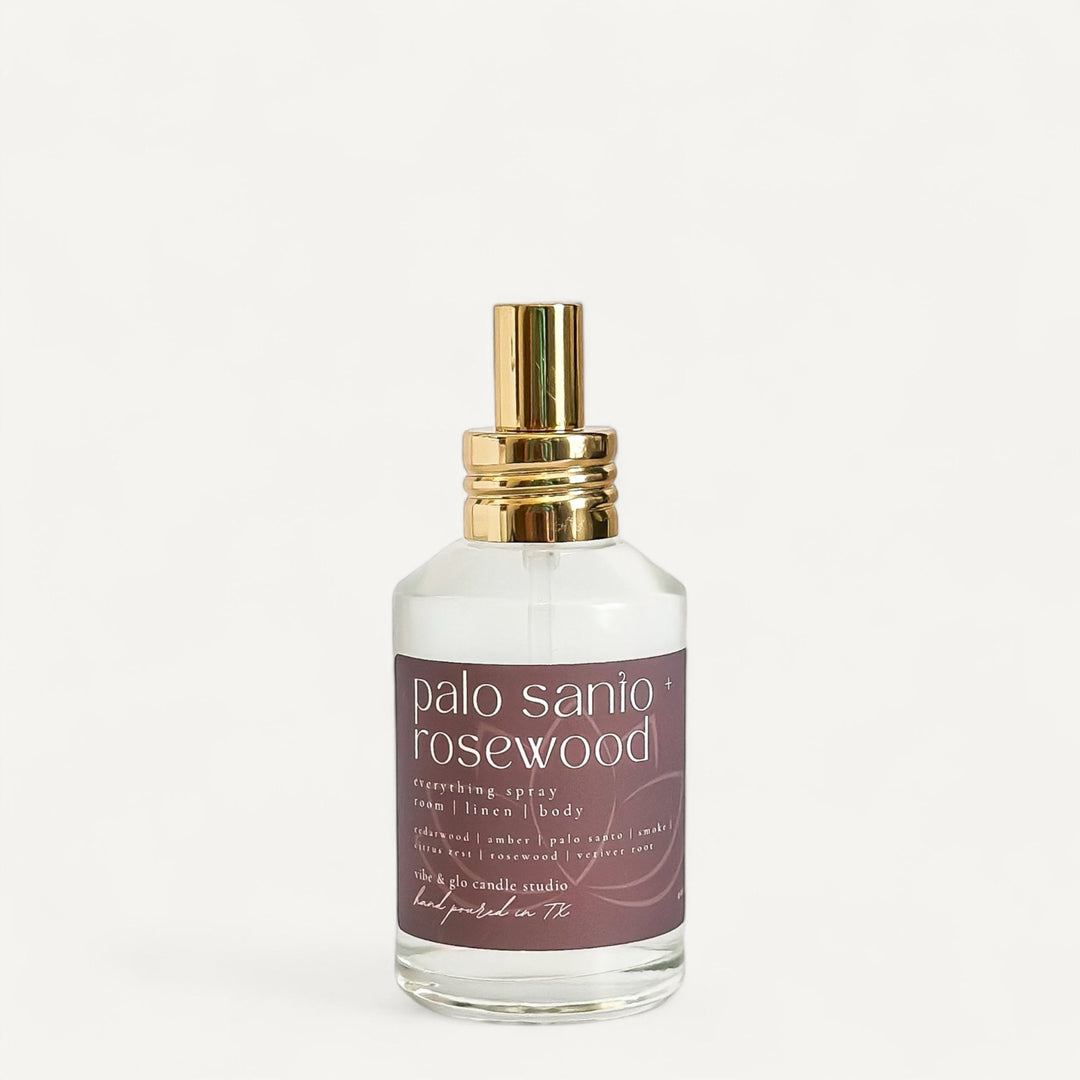 Palo Santo and Rosewood room and linen spray bottle with a gold cap, promoting earthy and grounding aroma.
