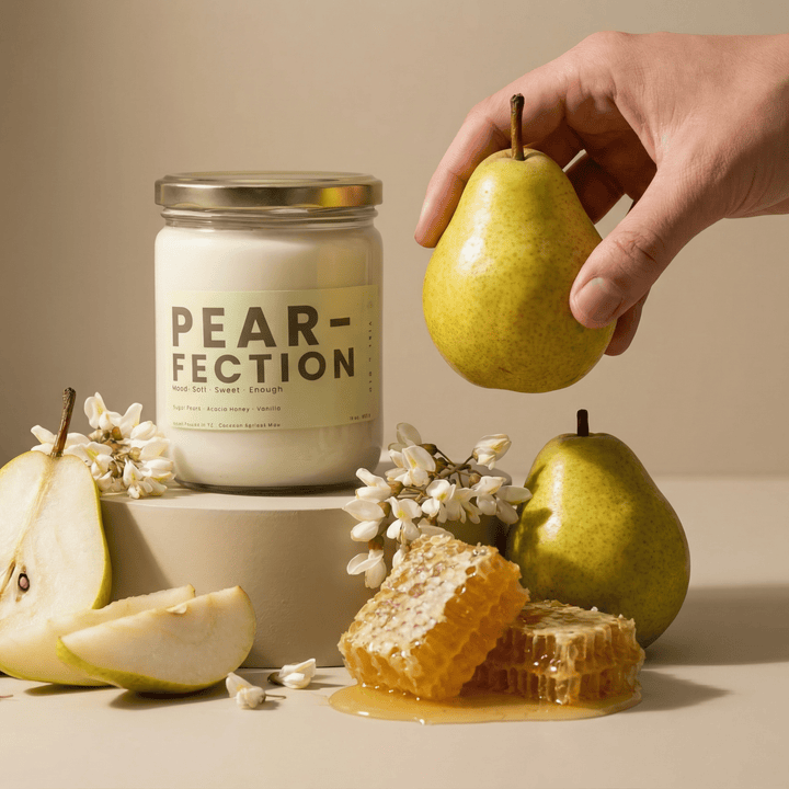 Pear-Fection candle styled with sliced pears and honeycomb, sweet pear and honey scented candle with hand holding fresh pear