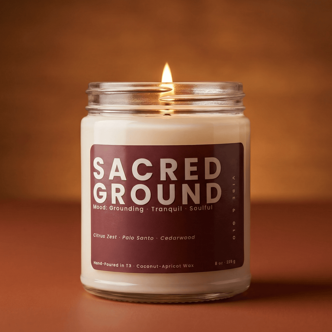 Sacred Ground clean burning candle with a warm amber glow featuring grounding notes of citrus zest palo santo and cedarwood