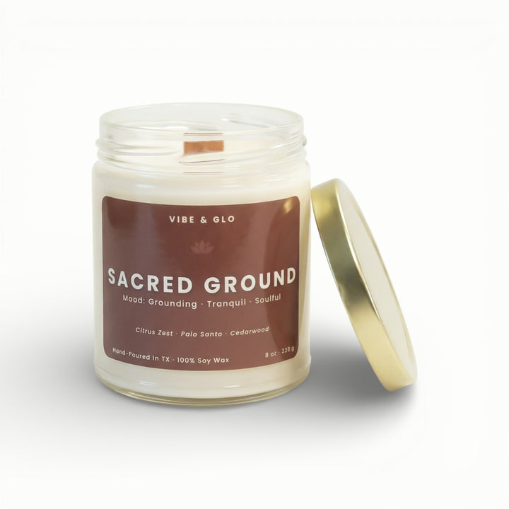 Vibe & Glo Sacred Ground soy candle in clear glass jar with wooden wick and gold lid, citrus zest palo santo and cedarwood fragrance