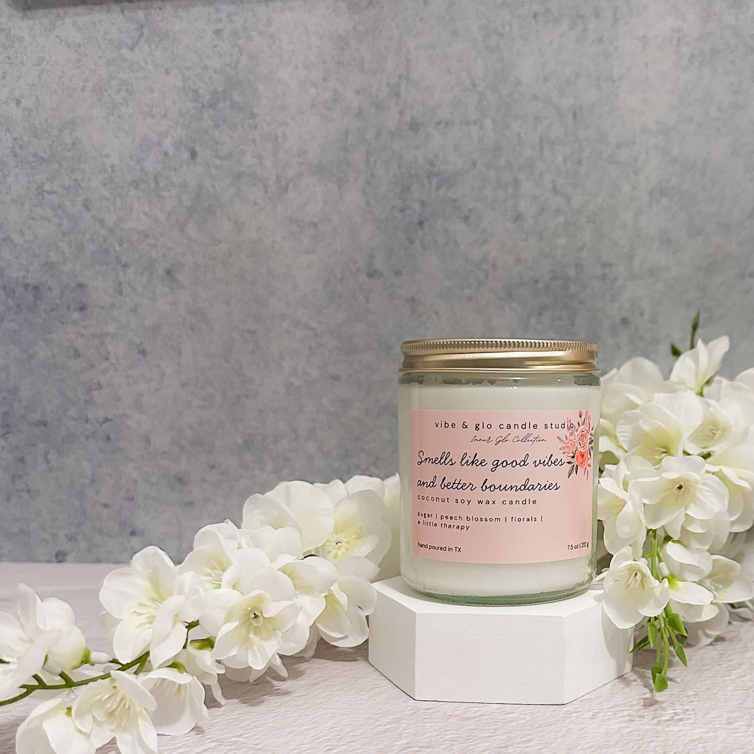 Smells like good vibes and better boundaries coconut soy wax candle with sugar, peach blossom, and florals. Styled with white flowers for a bright, floral aesthetic.