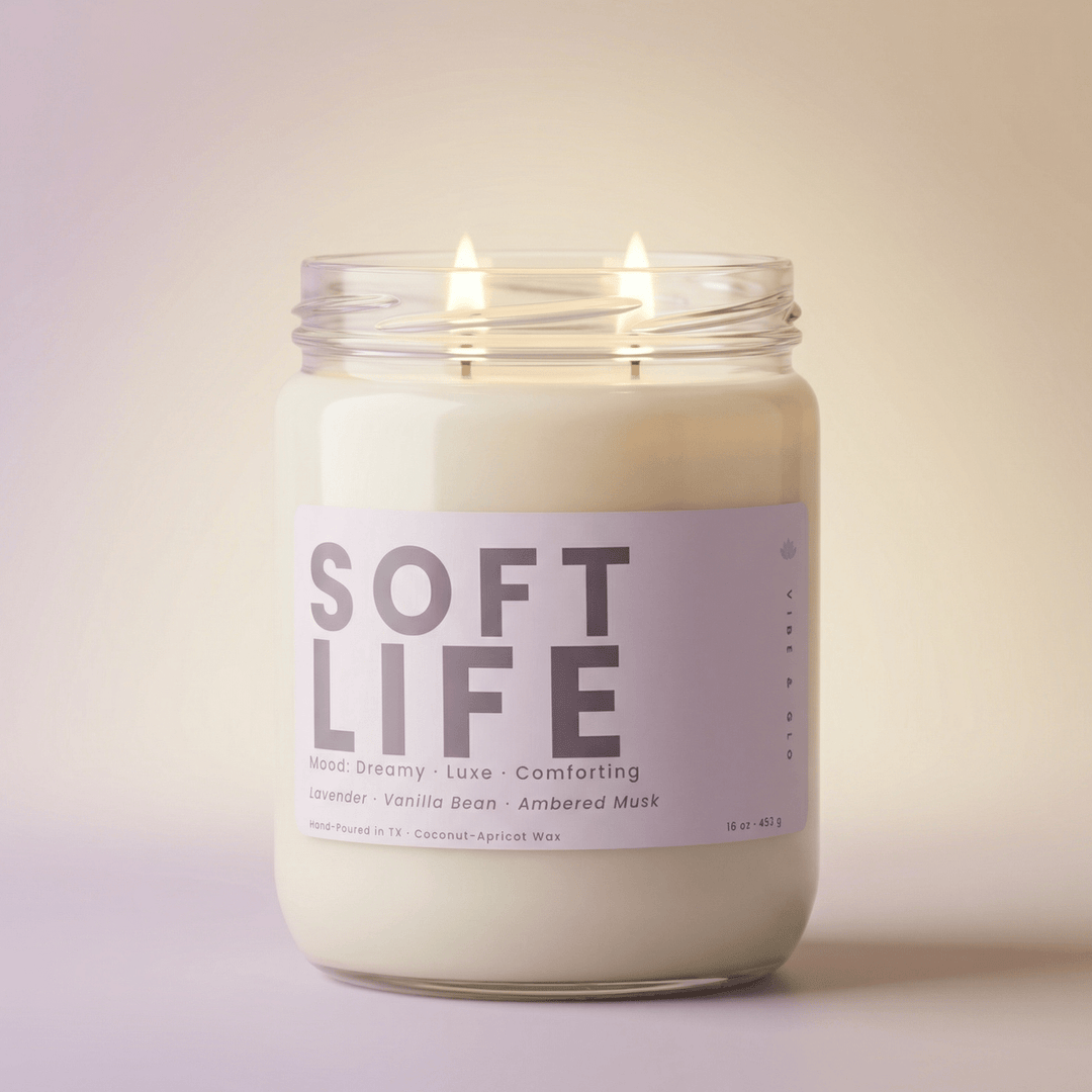 Soft Life 2-wick candle with two cotton wicks burning on a soft neutral background, relaxing lavender vanilla candle