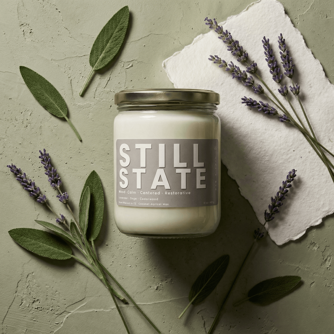 Still State 2-wick candle styled with lavender sprigs and sage leaves, highlighting calming herbal fragrance notes
