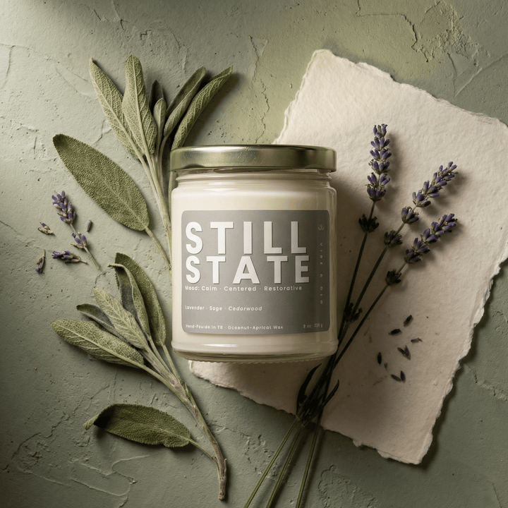 Still State herbal candle with lavender sprigs and sage leaves styled in a calming natural flatlay