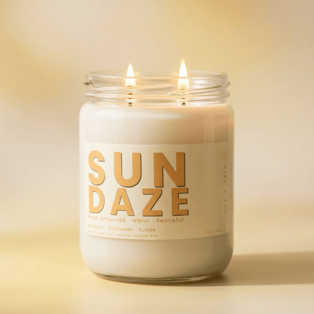 Sun Daze 2-wick candle with two cotton wicks burning on a soft golden background, warm uplifting citrus candle