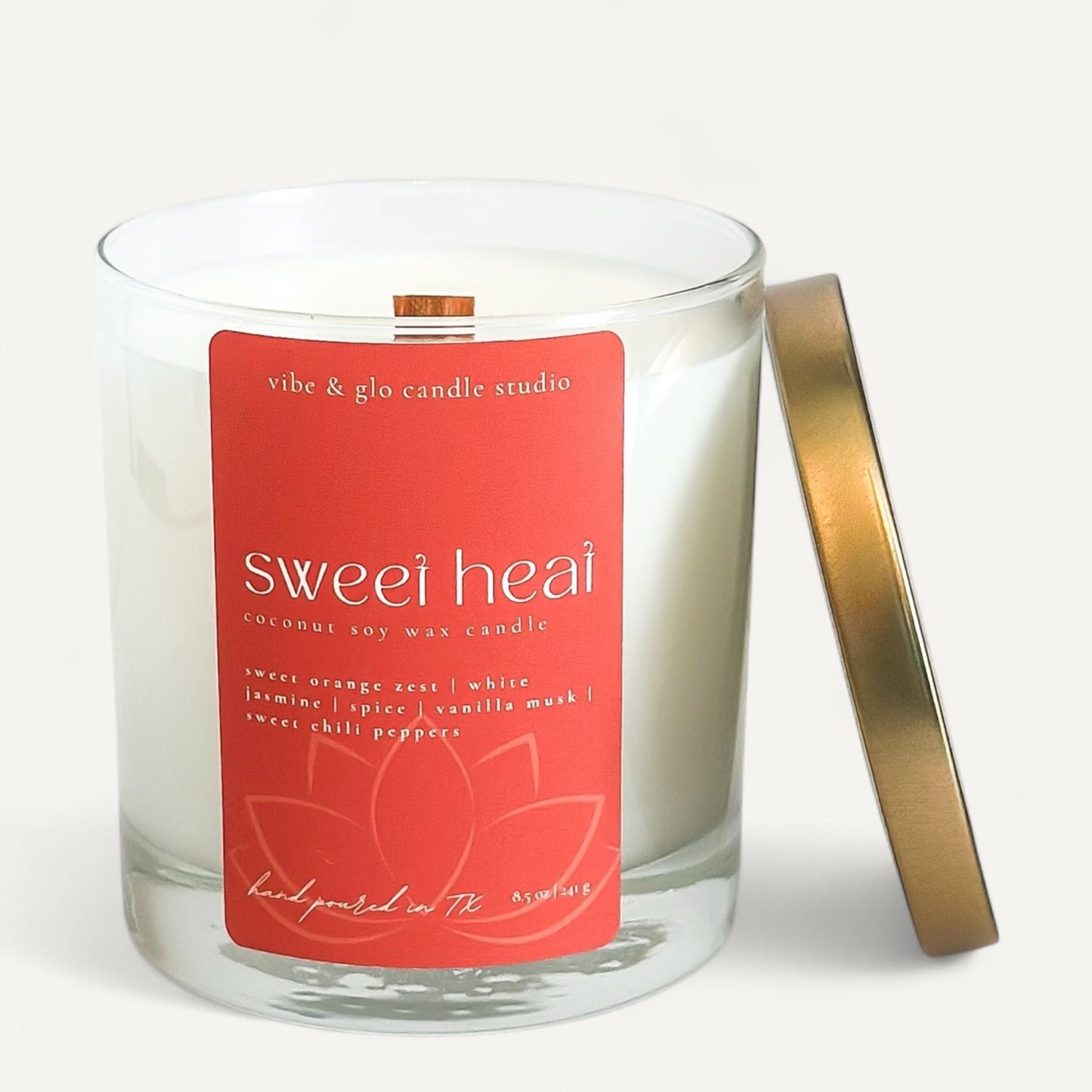 Sweet Heat coconut soy wax candle by Vibe and Glo with bold red label and gold lid.