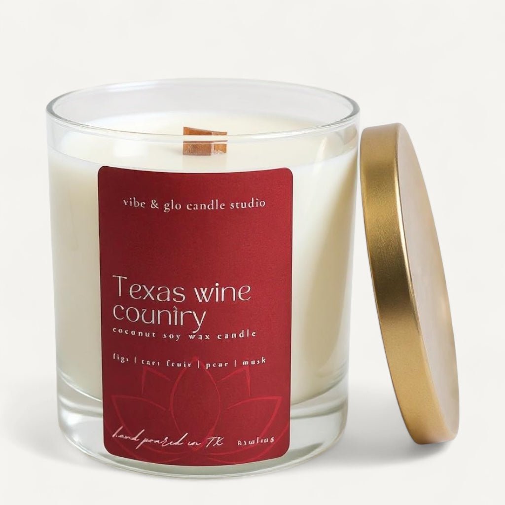 Vibe & Glo Texas Wine Country candle with fig, tart fruit, pear, and musk scents, displayed in a clear glass jar with a gold lid.