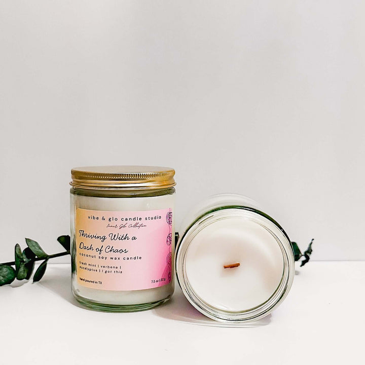 Thriving With a Dash of Chaos coconut soy wax candle with fresh mint, verbena, and eucalyptus. Displayed with greenery for a fresh, botanical aesthetic.