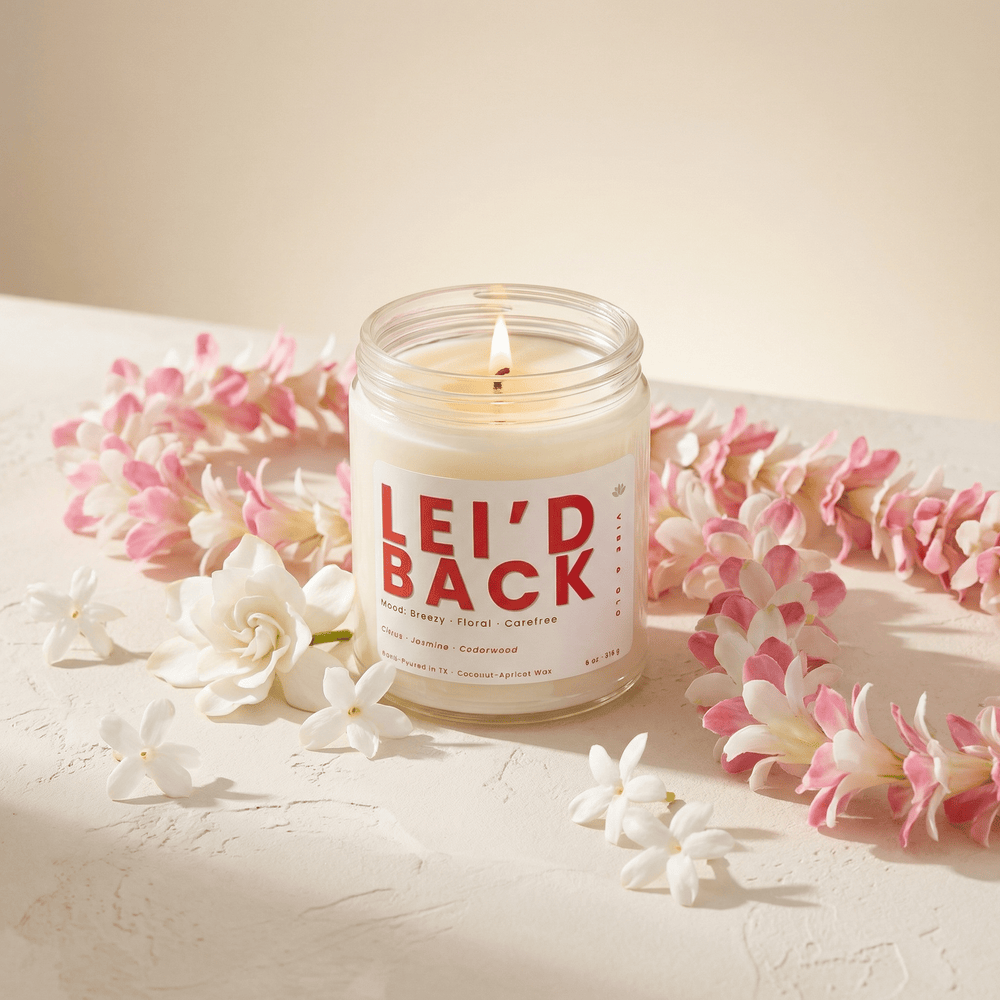 Tropical floral candle with jasmine and floral lei styled in a soft, breezy summer setup