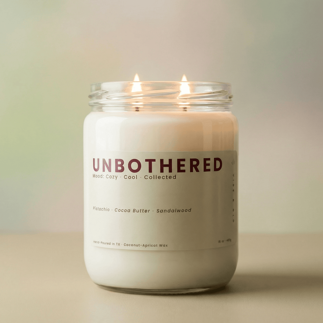 Unbothered 2-wick candle glowing in soft neutral light, cozy gourmand candle with pistachio cocoa butter and sandalwood scent