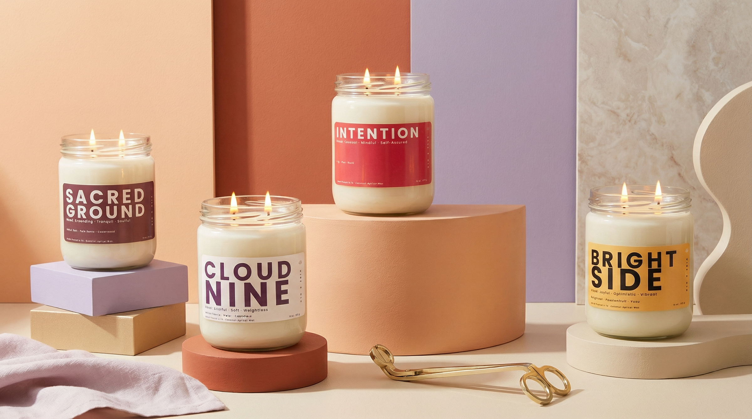 Vibe and Glo 2 wick candle collection featuring Intention, Cloud Nine, Sacred Ground, and Bright Side candles with dual flames styled in a modern colorful setting