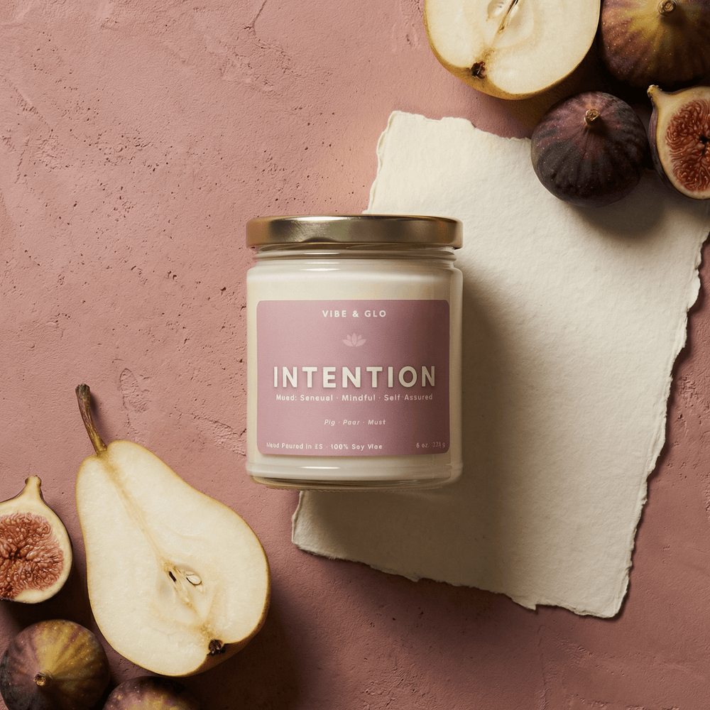 Intention 8 oz soy candle by Vibe & Glo featuring fig, pear, and musk, arranged with ripe figs and pear slices in a sensual flatlay composition.