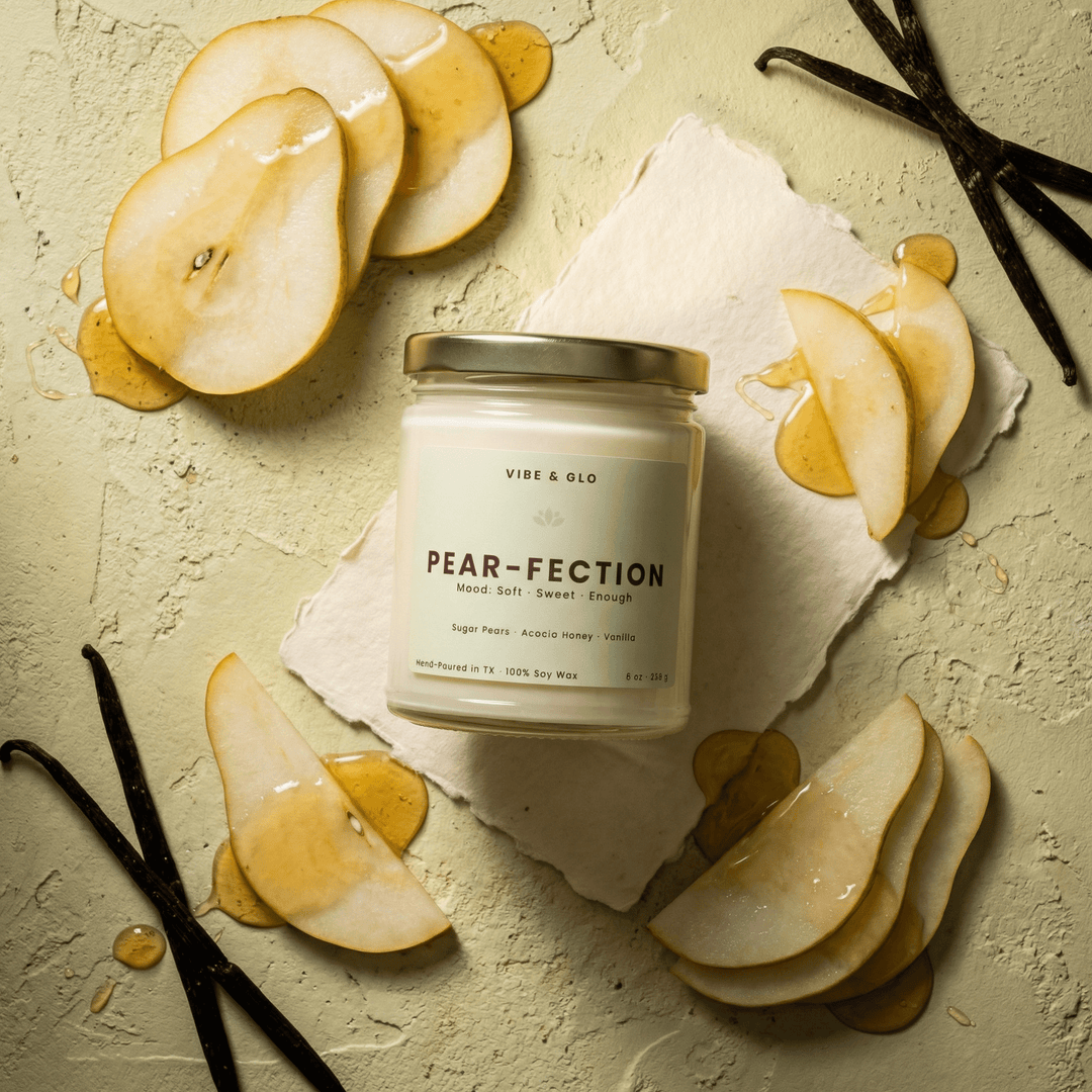 Pear-Fection 8 oz soy candle by Vibe & Glo featuring sugar pears, acacia honey, and vanilla with pear slices and honey drizzle in a fresh green flatlay.