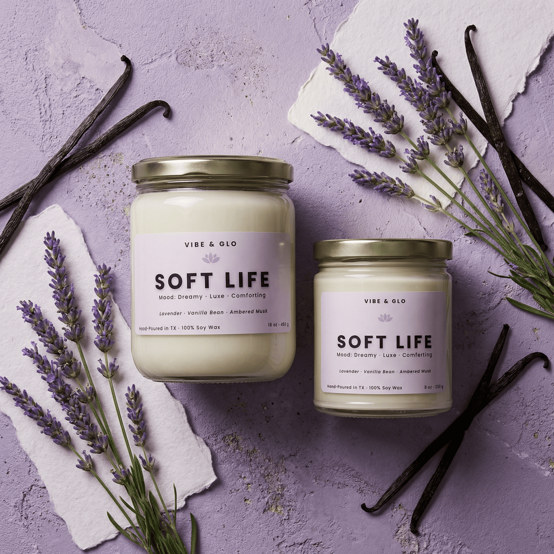 Soft Life lavender vanilla soy candles in 16 oz and 8 oz jars with gold lids, styled with fresh lavender sprigs and whole vanilla beans on a lavender-toned surface.