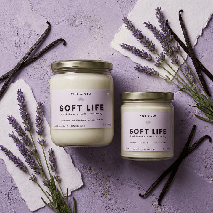 Soft Life lavender vanilla soy candles in 16 oz and 8 oz jars with gold lids, styled with fresh lavender sprigs and whole vanilla beans on a lavender-toned surface.
