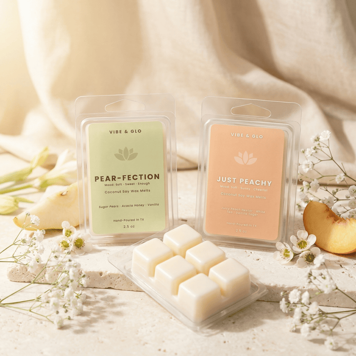Vibe & Glo spring coconut soy wax melts featuring Pear-Fection and Just Peachy scents styled with fresh florals and fruit slices on a neutral stone surface.