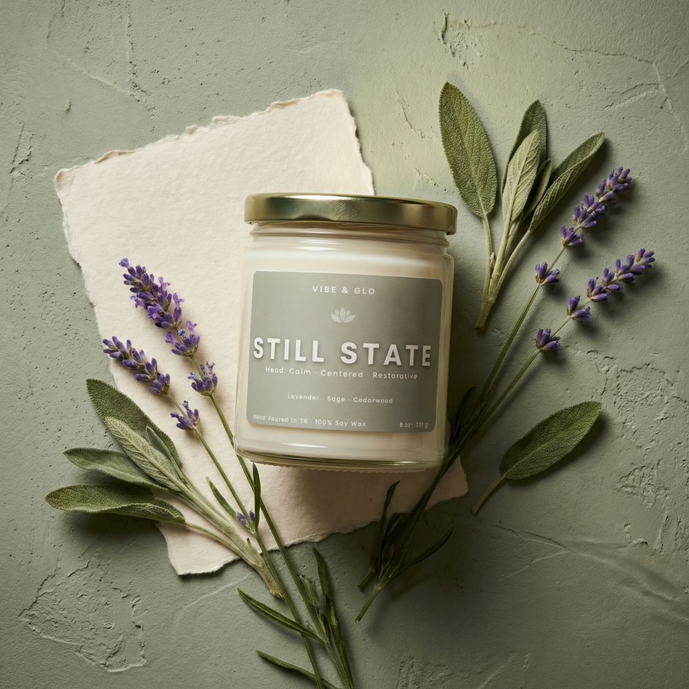 Still State 8 oz soy candle featuring lavender, sage, and cedarwood surrounded by calming botanicals in a serene spa-inspired flatlay.