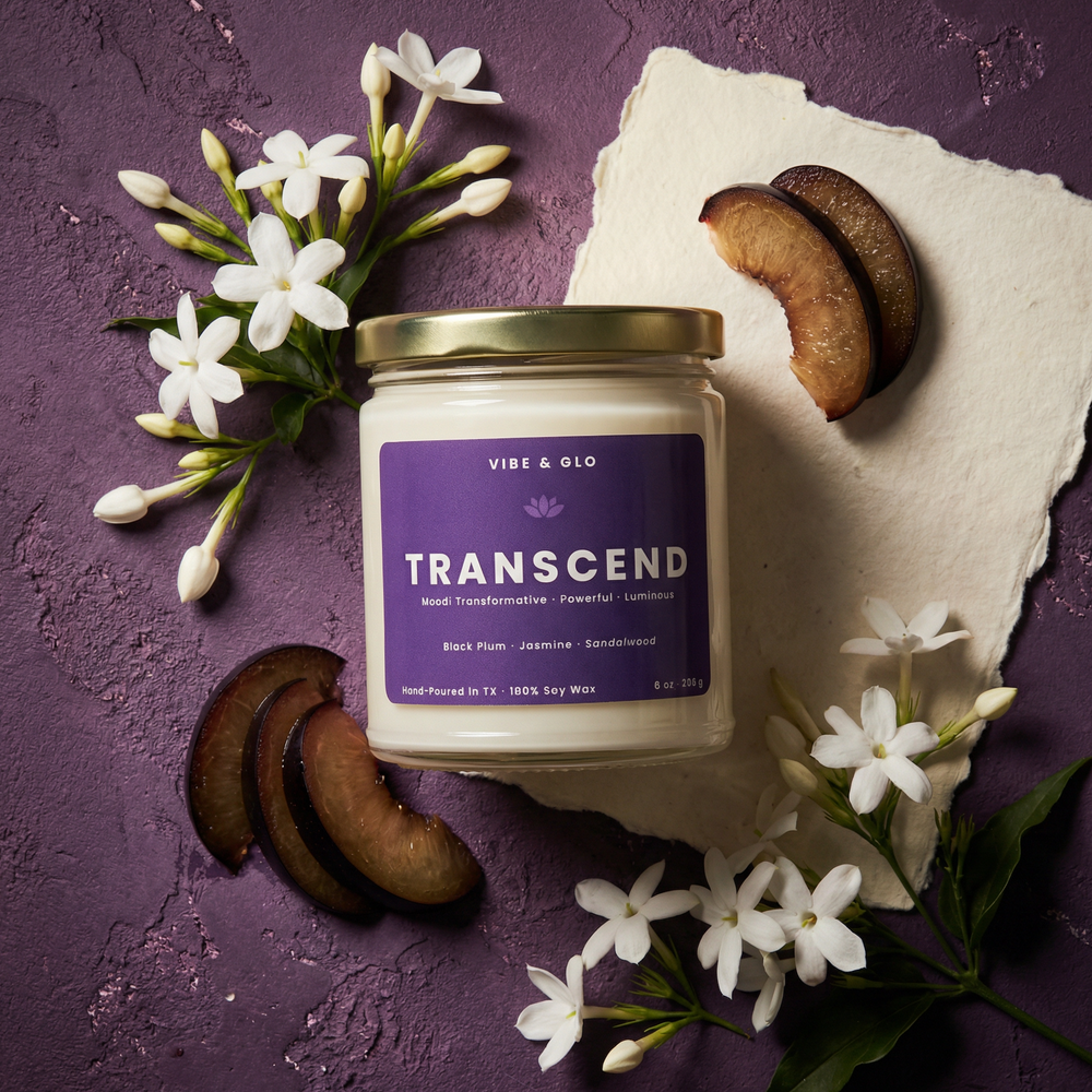 Transcend 8 oz soy candle featuring black plum, jasmine, and sandalwood with plum slices and jasmine blooms in a bold purple flatlay composition.