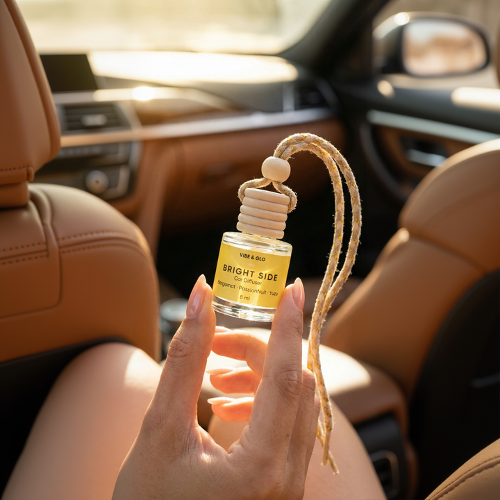 Hand holding a 'Bright Side' car air freshener in a car interior